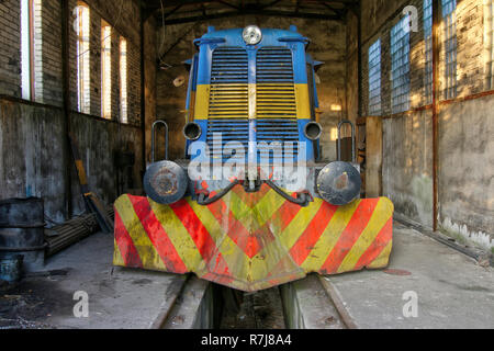 Old abandoned diesel locomotive in a former factory Stock Photo