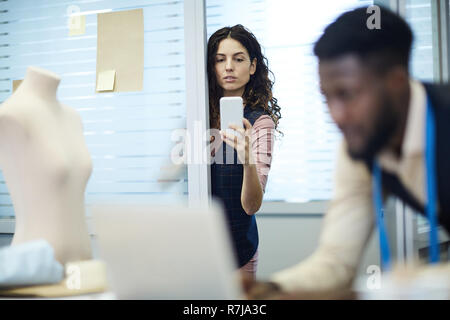 Woman photographing clothing designer at work Stock Photo