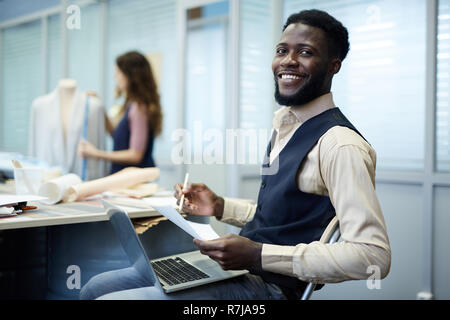 Excited African-American fashion designer in studio Stock Photo
