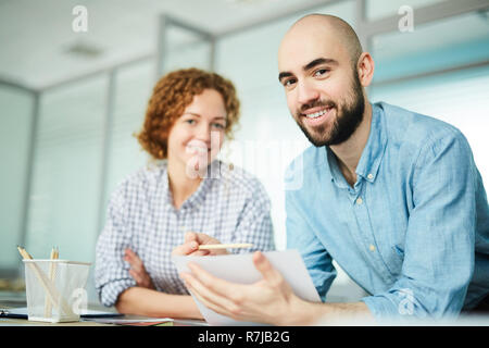 Positive young colleagues working on design project in office Stock Photo