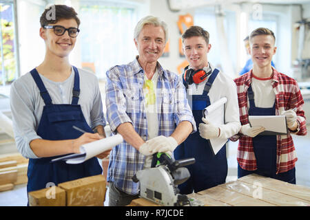 Carpenter and his students in workshop Stock Photo