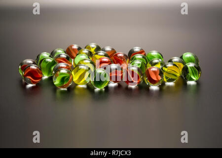 Group of colored glass balls on a dark gray background closeup Stock Photo