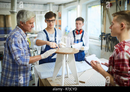 Carpentry students asking questions at practical class on furnit Stock Photo