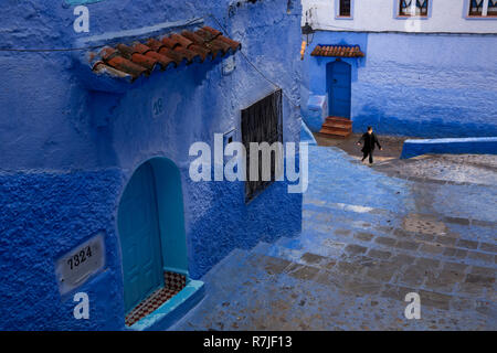 Morocco, Chefchaouen, Medina, child at bottom of narrow street of blue painted hillside houses Stock Photo