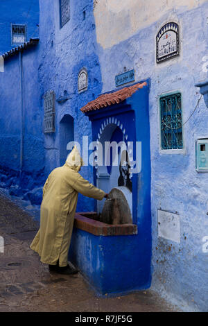 Mc457Morocco, Chefchaouen, Medina, Avenida Autiui, man in Djellaba at traditional water fountain Stock Photo