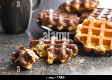 Waffles with chocolate topping on old kitchen table. Stock Photo