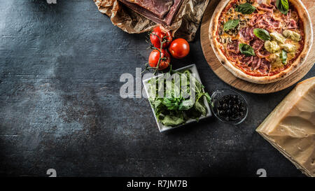 Pizza Quatro Stagioni four seasons traditional italian meal from artichokes mushrooms tomatoes ham prosciutto parmesan cheese and basil -  Top of view Stock Photo