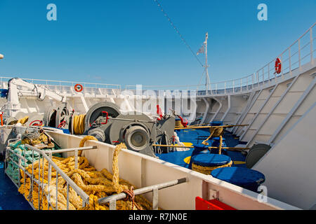 Ship stern deck with nautical ropes, mooring winch, hook and lifebuoy on sunny blue sky background in Philipsburg, Sint Maarten. Sea voyage and travelling. Yachting and boating concept Stock Photo