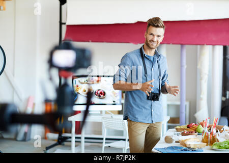 Portrait of handsome TV show host filming cooking program in studio , copy space Stock Photo