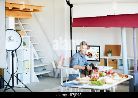 Portrait of handsome photographer looking at camera while working in studio, copy space Stock Photo