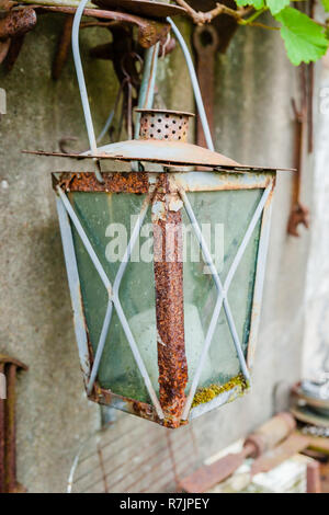 Close-up of red rusty vintage lantern hanging on a old wall Stock Photo