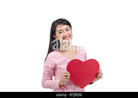 Smiling asian woman with red paper heart standing isolated over white background. Valentines day Stock Photo