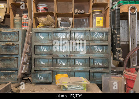 An old set of parts drawers with imperial american measurements marked on each drawer in a workshop Stock Photo
