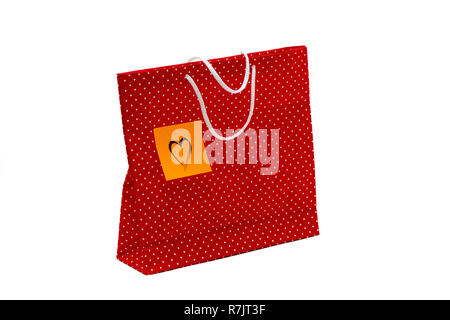 Gift bag with heart shape message, written by hand. Red polka dot paper bag isolated on white background. Stock Photo