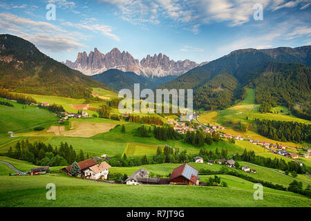 Dolomite alps with a mountain village and green meadows Stock Photo - Alamy