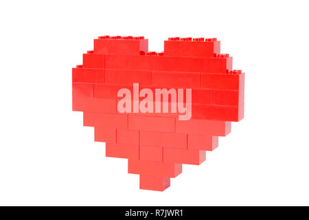 Side view of a red heart made of toy building bricks, isolated on white background. Stock Photo