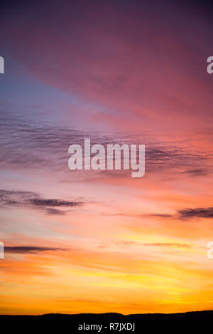 Dramatic sky with big clouds in the sunset. The sun is beautifully breaking through the clouds. Vertical Stock Photo
