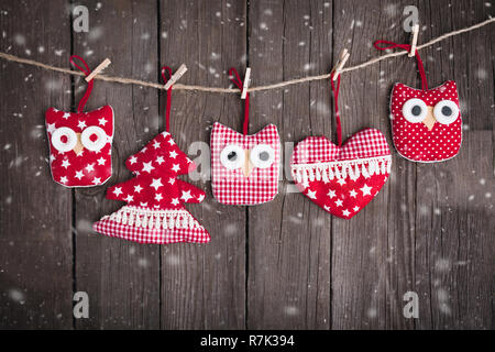 Christmas ornaments hanging on string over wooden background Stock Photo