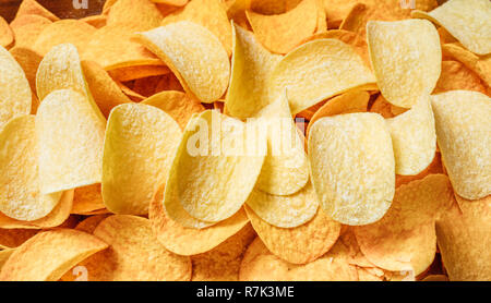 Chips texture crisp potato background of golden unhealthy food . Stock Photo