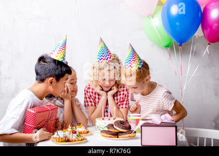 excited surprised rejoicing kids are gazering at cake Stock Photo