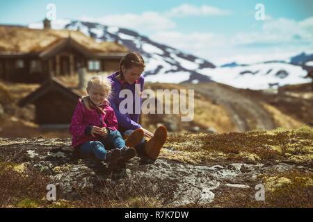 girl hiker sitting on a background of an old traditional wooden houses in Tyin, Norway