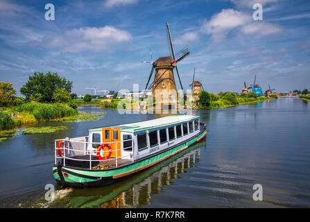 Kinderdijk, Netherlands - June 27, 2018: Netherlands rural lanscape with tourist boat and windmills at famous tourist site Kinderdijk in Holland. This Stock Photo