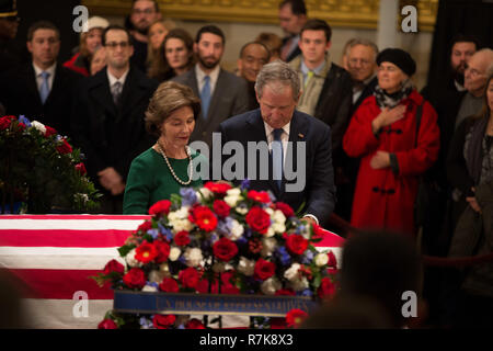 Former President George W. Bush and his wife Laura pay respect to his fathers flag draped casket, former President George H. W. Bush as as it lies in state at the Capitol Rotunda December 4, 2018 in Washington, DC. Bush, the 41st President, died in his Houston home at age 94. Stock Photo