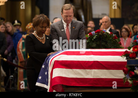 Neil Bush, center, pays his respects to his fathers flag draped casket, former President George H. W. Bush as as it lies in state at the Capitol Rotunda December 4, 2018 in Washington, DC. Bush, the 41st President, died in his Houston home at age 94. Stock Photo