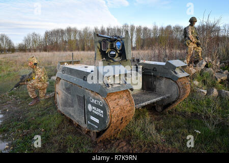 STANDALONE PHOTO Soldiers surround a Titan Strike unmanned ground vehicle, equipped with a .50 Caliber machine gun, moves and secures ground on Salisbury Plain during exercise Autonomous Warrior 18, where military personnel, government departments and industry partners are taking part in Exercise Autonomous Warrior, working with NATO allies in a groundbreaking exercise to understand how the military can exploit technology in robotic and autonomous situations. Stock Photo