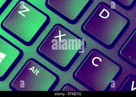 Close up image of Green purple keyboard with x key Stock Photo