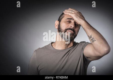 tired caucasian bearded long hair man studio portrait Stock Photo