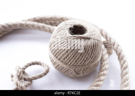 Thin twine tangled in a ball and rope witk dragon loop. There are several  threads of rope around the ball Stock Photo - Alamy
