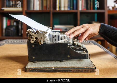 woman hands type on an old vintage dust-covered typewriter Stock Photo