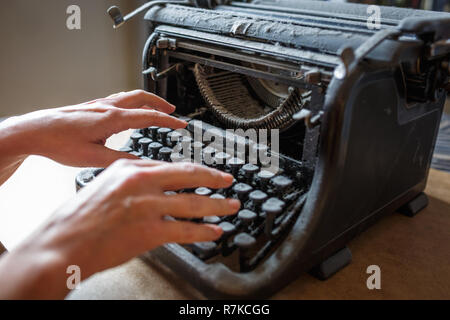 woman hands type on an old vintage dust-covered typewriter Stock Photo
