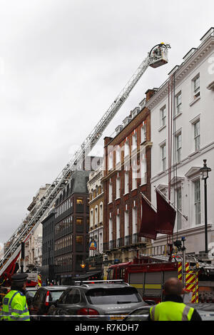 LONDON, UNITED KINGDOM - JANUARY 28: Fire Brigade fights flames in London on JANUARY 28, 2013. Fire Fighters with telescopic boom ladder in Albemarle  Stock Photo