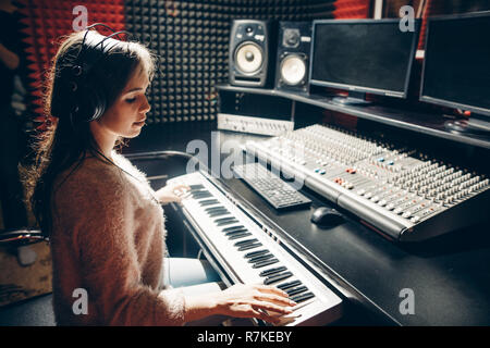 close up side view photo. talented beautiful girl plaing on the synthesizer Stock Photo