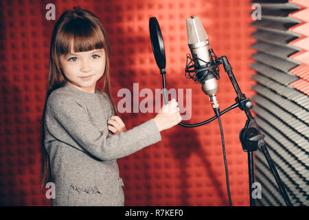 awesome little girl singing songs in the music recording studio Stock Photo