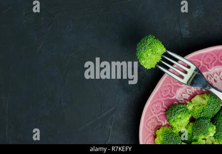 Healthy food Fresh broccoli on a plate on a black background. view from above. copy space. Stock Photo