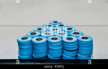 Pyramid of piles of blue poker chips on table with copy space - tournament poker chip leader Stock Photo