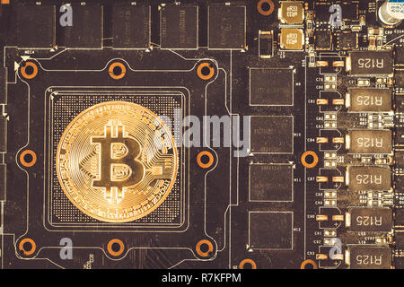 Bitcoin coin lies on the video card Stock Photo