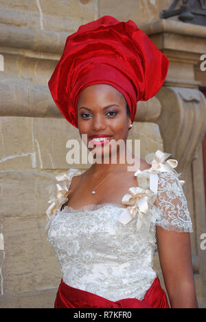 Posed portrait of a beautiful Nigerian American woman in an ethnic red hat in Florence, Italy for a friend's milestone birthday party. Stock Photo