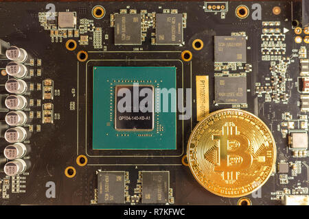 Bitcoin coin lies on the video card Stock Photo