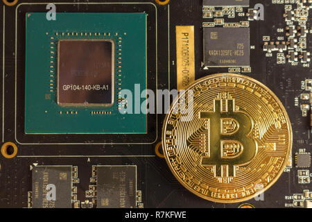 Bitcoin coin lies on the video card Stock Photo