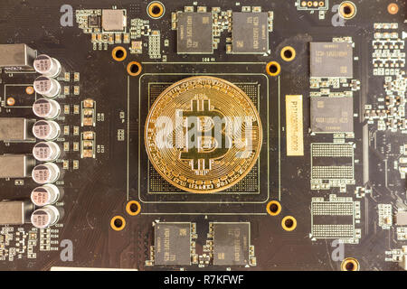 Bitcoin coin lies on the video card Stock Photo
