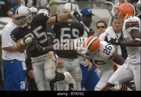 Cincinnati Bengals HB Chris Perry (23) is tackled by Cleveland Browns Sean  Jones (26) and Andra Davis (54) after a ten yard gain, during the second  quarter at the Cleveland Browns Stadium