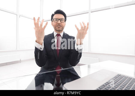 serious businessman explains something sitting at his Desk Stock Photo