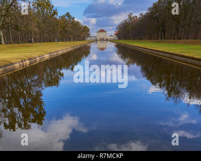 Nymphenburg castle, Munich, Germany, view along the canal , nice clouds in the sky, reflections in the water. Stock Photo