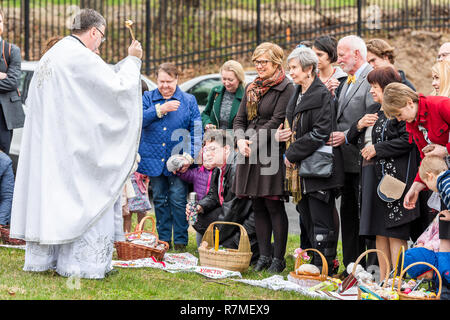 Washington DC, USA - April 1, 2018: People, priest praying, holding sprinkling holy water, Easter baskets at Ukrainian Catholic National Shrine of Hol Stock Photo
