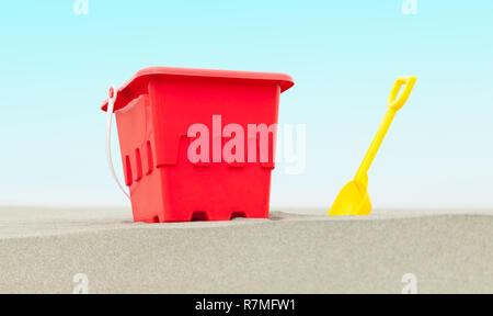 Red Bucket and Yellow Shovel in Beach Sand with Blue Sky. Stock Photo