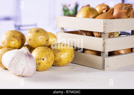 Ingredients. recipe step by step baked potatoes with onion with wooden crate with red flowers on white in background Stock Photo